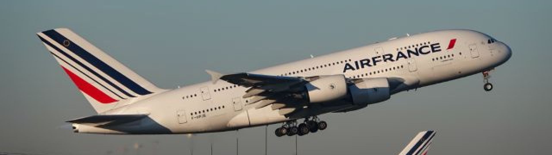 An Air France plane taking off from the runway, flying left to right.