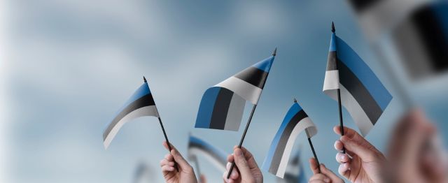 Des mains agitent des drapeaux estoniens - Pourquoi tant d'entrepreneurs créent une entreprise en Estonie ?