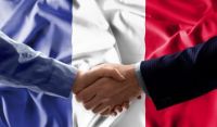 Businessmen shaking hands in front of French flag
