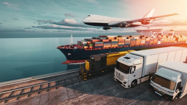 Plane, container ship and two lorries travelling left