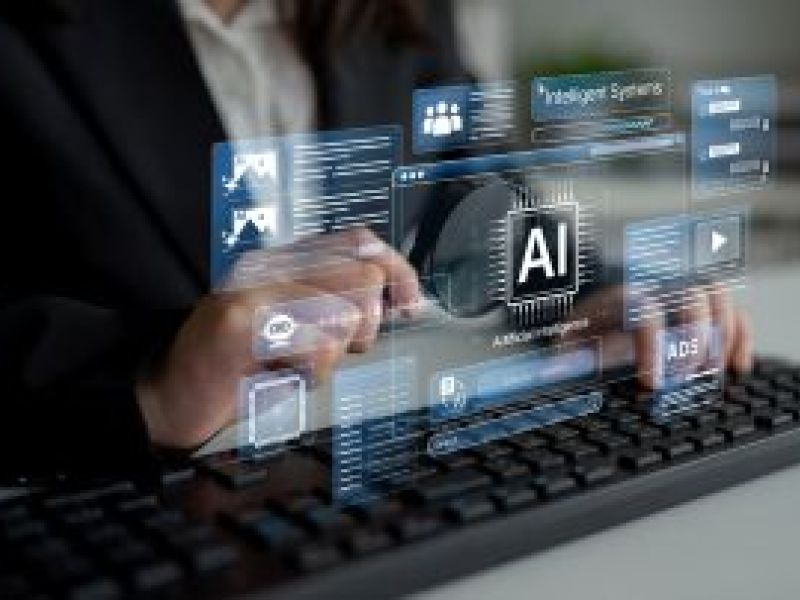 Suited man tapping on keyboard with AI holograph