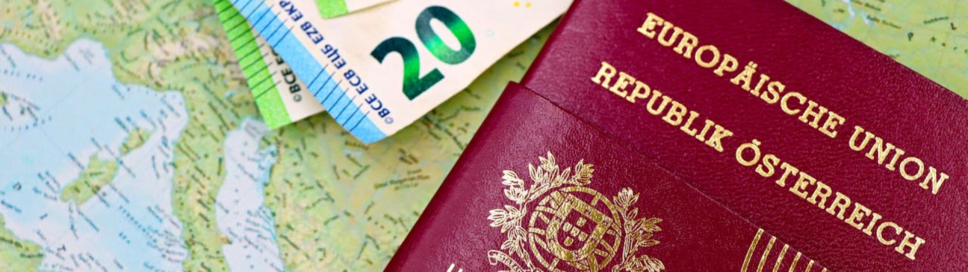 A passport on top of a map with several euro banknotes