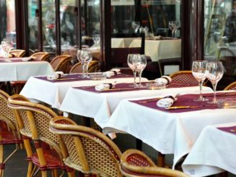 Alignement de tables nappées de blanc sur la terrasse d'un restaurant français
