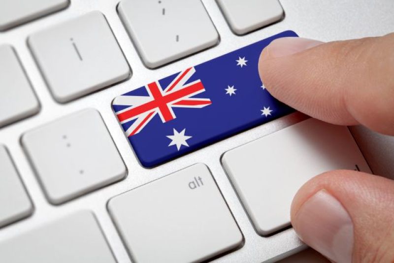 Finger pushing on computer keyboard with Australian flag symbol